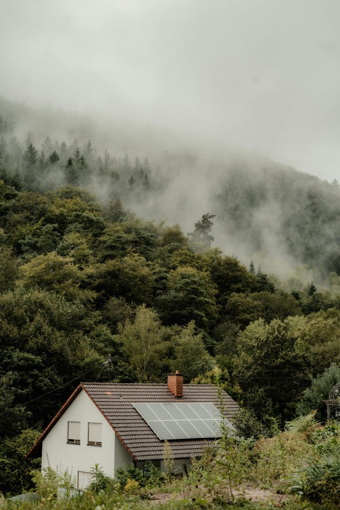 pexels-photo-28286652-28286652 A house with solar panels nestled in a foggy forest, offering a serene and eco-friendly setting.